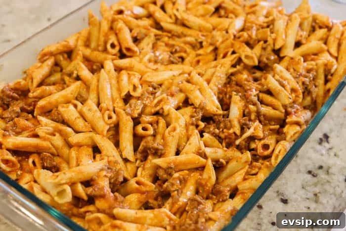 adding pasta to a casserole dish to bake