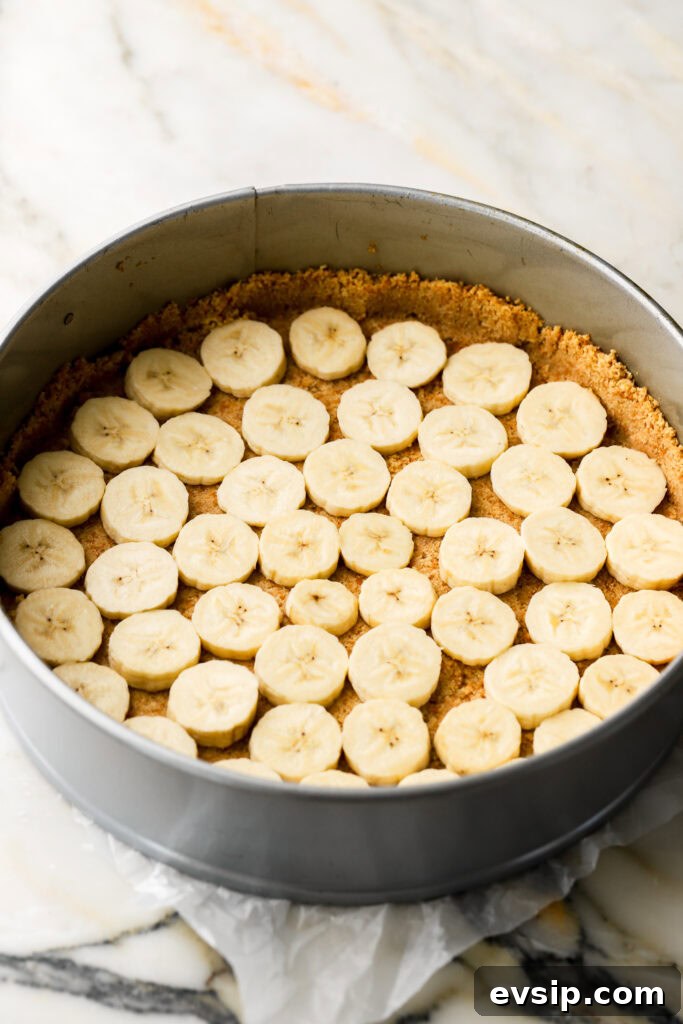 Banana Pudding Cheesecake Recipe with Creamy Layered Filling 9 banana slices on top of crust