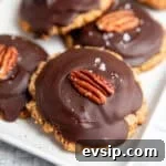 a tray of vegan turtles cookies set with a cookie base, caramel, hardened chocolate and a pecan on top