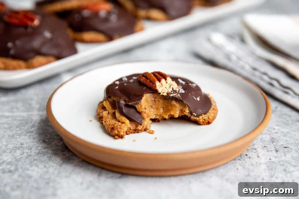 a bite taken out of a vegan turtle cookie showing the soft caramel middle