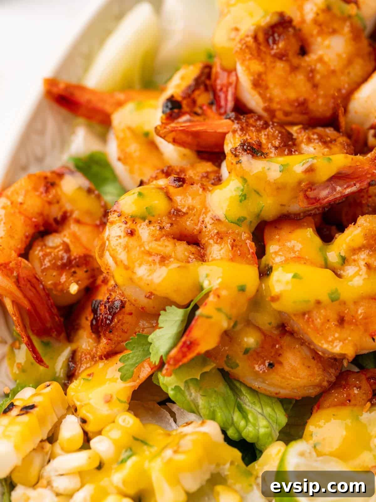 Close up of shrimp drizzled with mango salad dressing.