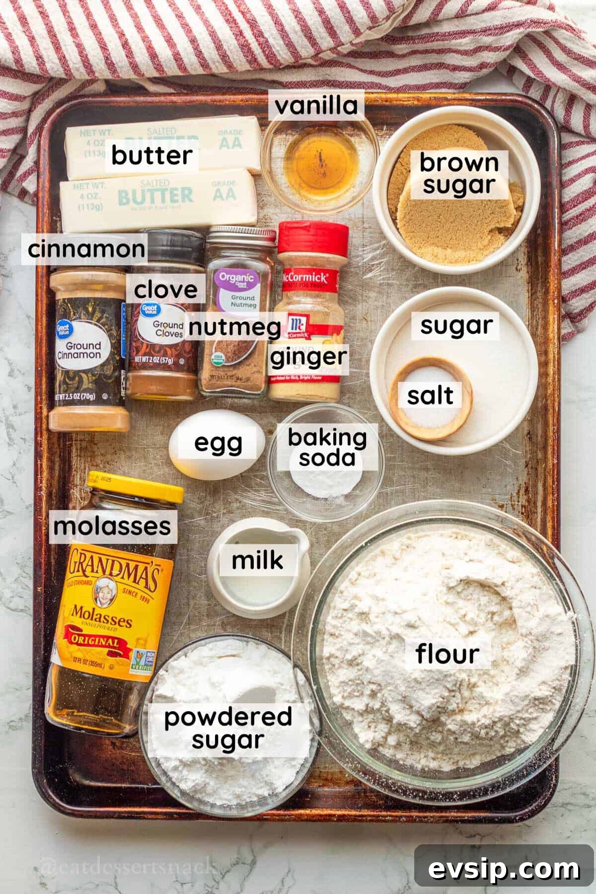 Ingredients for iced molasses cookies in glass dishes on metal baking sheet.