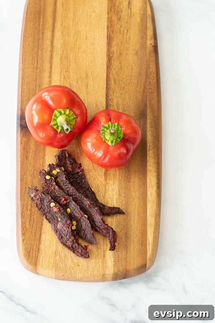 Cherry bomb beef jerky on cutting board with peppers