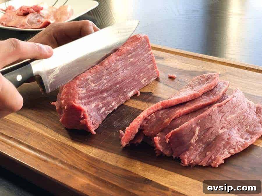 Eye of round beef roast being sliced in cutting board