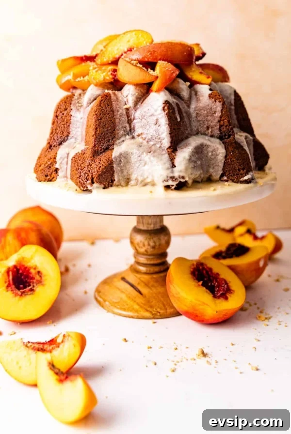pound cake on a cake stand topped with roasted peaches.