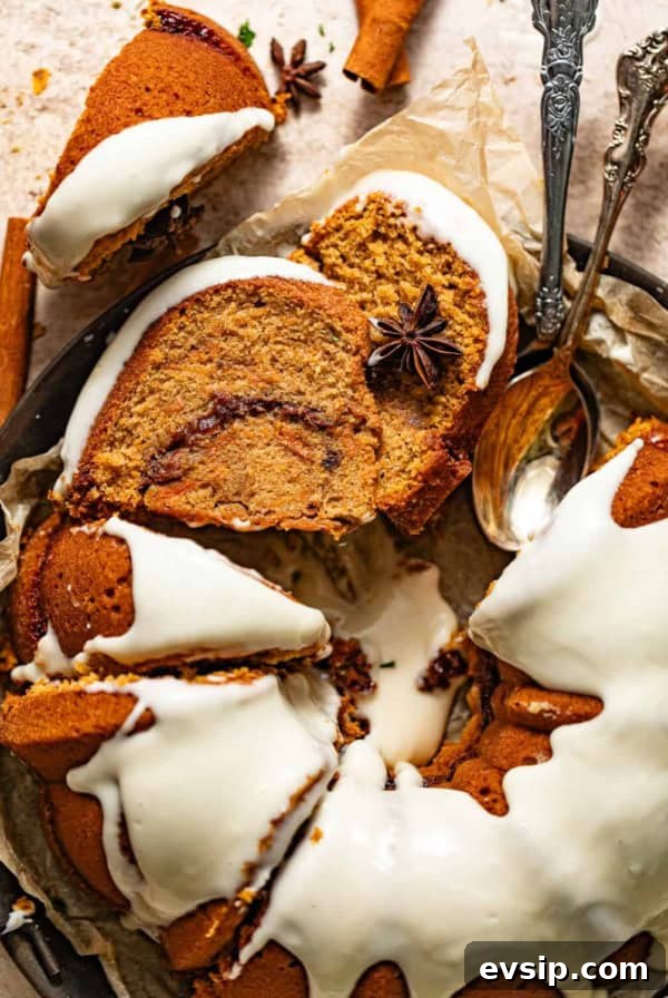 sweet potato pound cake topped with. cream cheese frosting on a serving plate with spoons.