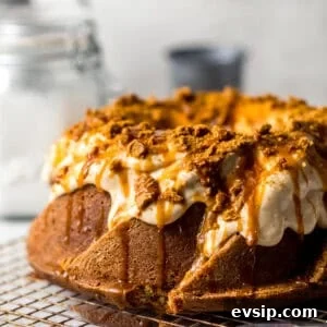 biscoff pound cake on a wire rack with glaze, caramel, and crushed cookies on top.