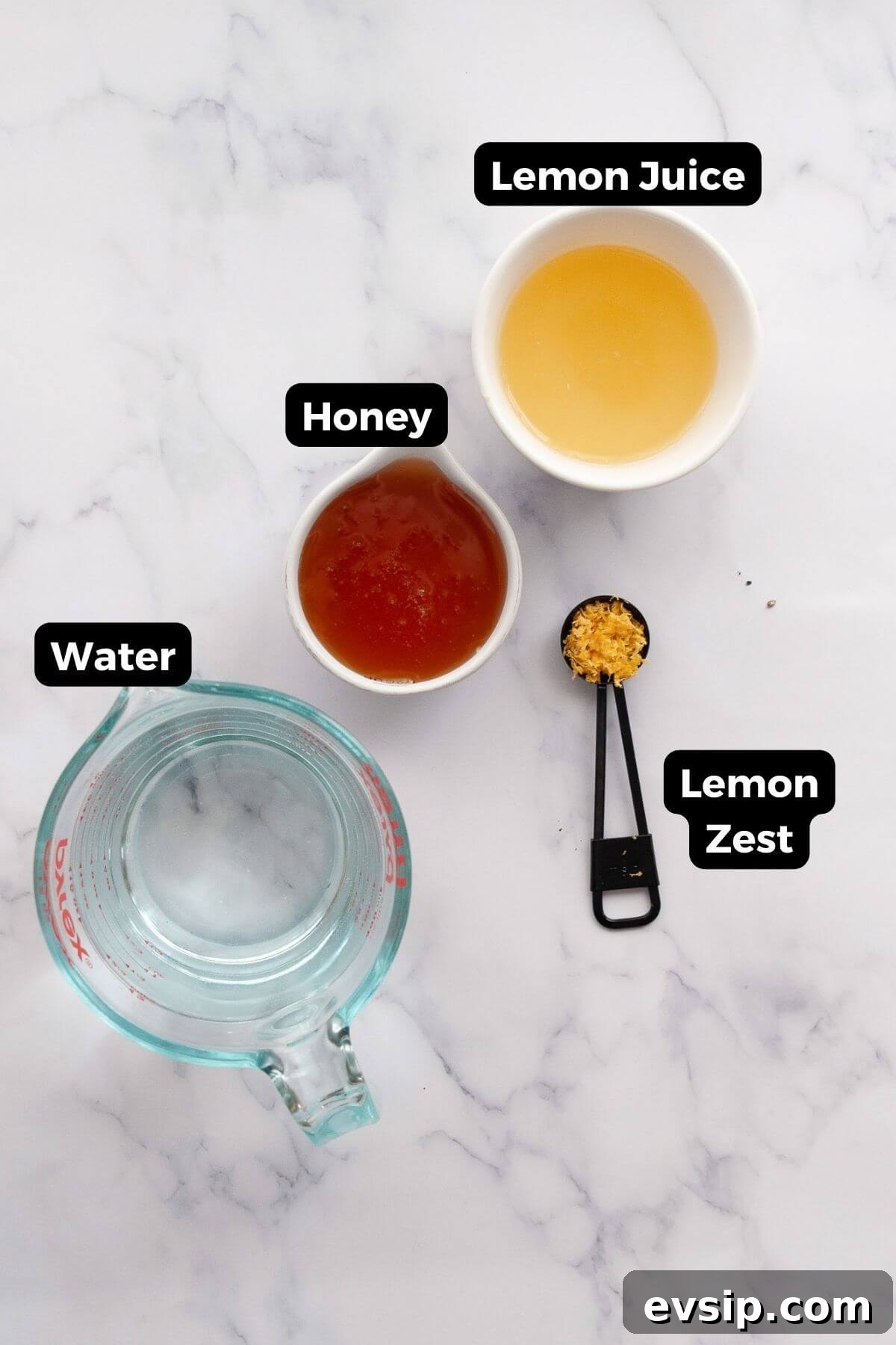Ingredients for homemade lemonade popsicles: fresh lemon juice, honey, water, and lemon zest in small bowls.