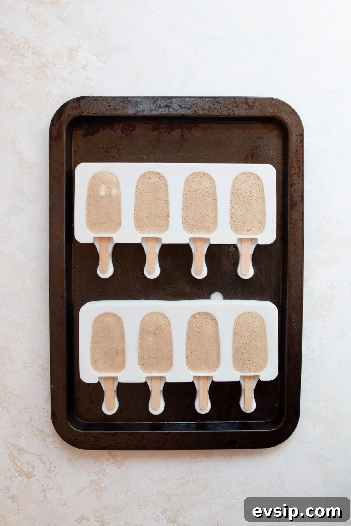 Frozen banana popsicles still in the molds, ready to enjoy.