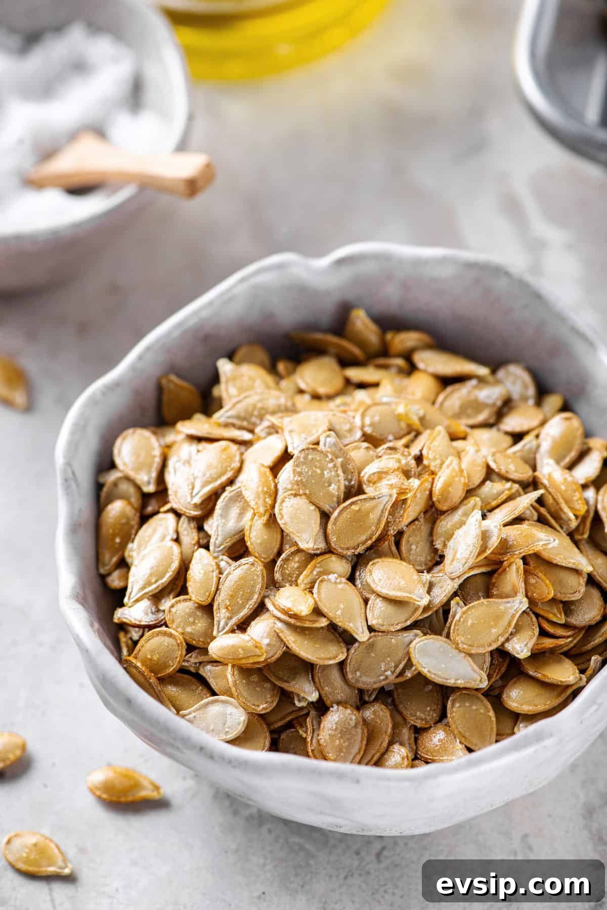 Crunchy Oven-Roasted Pumpkin Seeds for Snacking and Baking 2 roasted pumpkin seeds served in a grey bowl