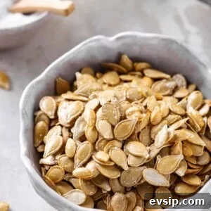 Crunchy Oven-Roasted Pumpkin Seeds for Snacking and Baking 7 roasted pumpkin seeds served in a white bowl