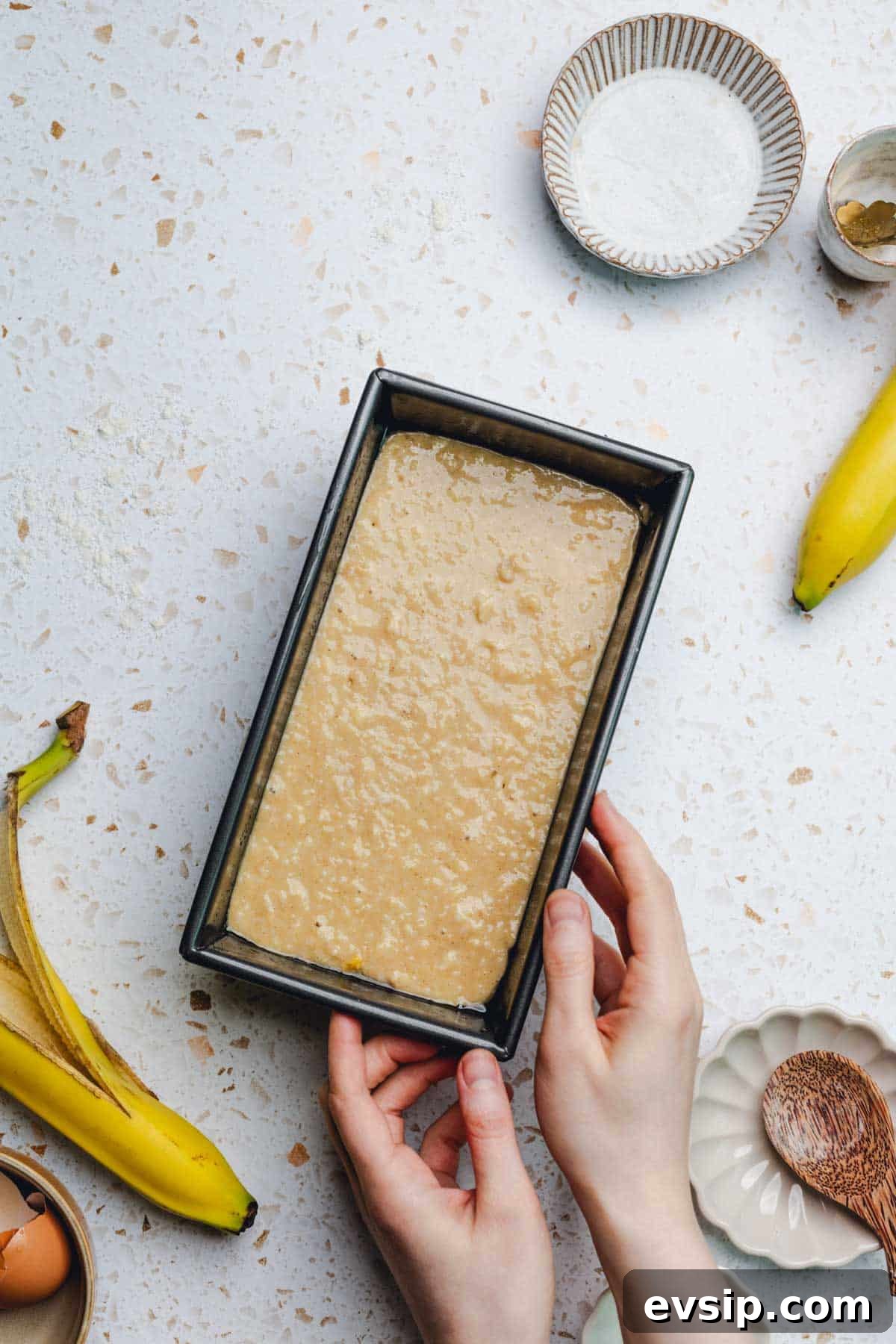 banana bread batter in a loaf pan. 