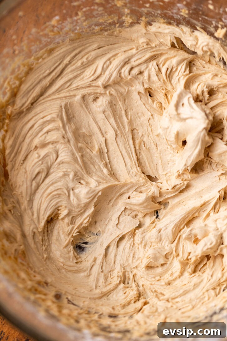 Decadent Snickers Dessert Cake Recipe for Chocolate Lovers 6 Peanut butter frosting in a bowl.