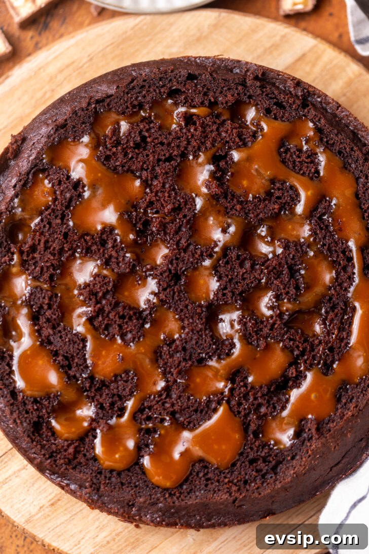 Decadent Snickers Dessert Cake Recipe for Chocolate Lovers 7 Cake poked with caramel.