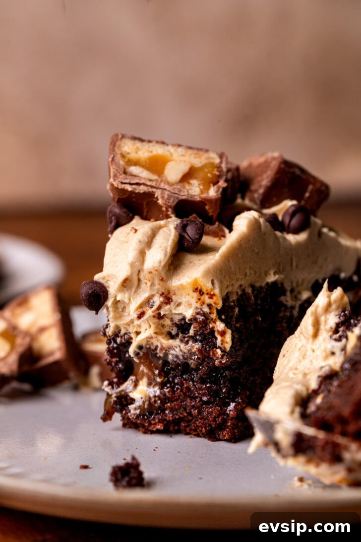 Decadent Snickers Dessert Cake Recipe for Chocolate Lovers 10 Bite missing from a piece of cake on a plate.