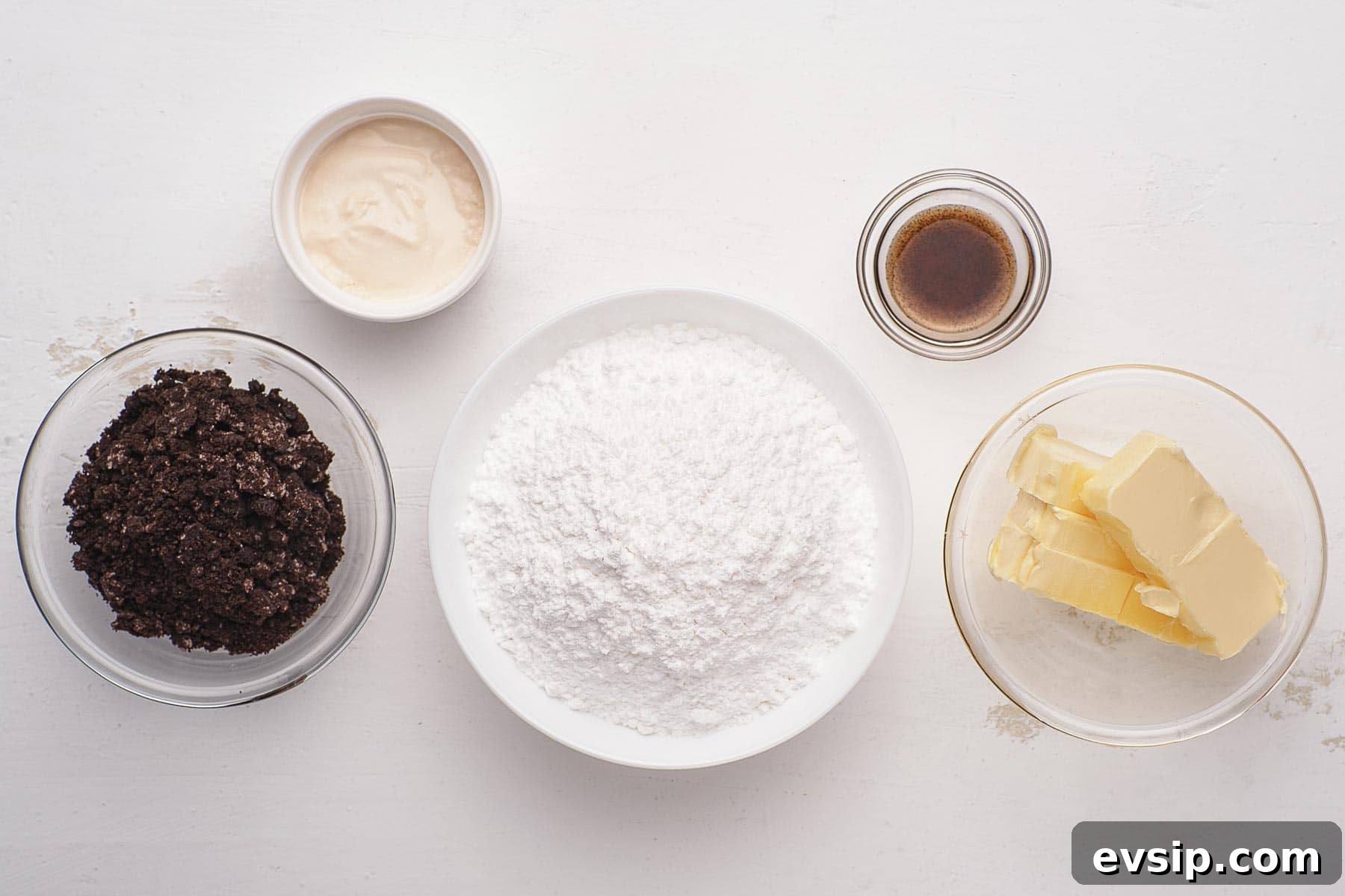 Ingredients for cookies and cream frosting in small bowls.