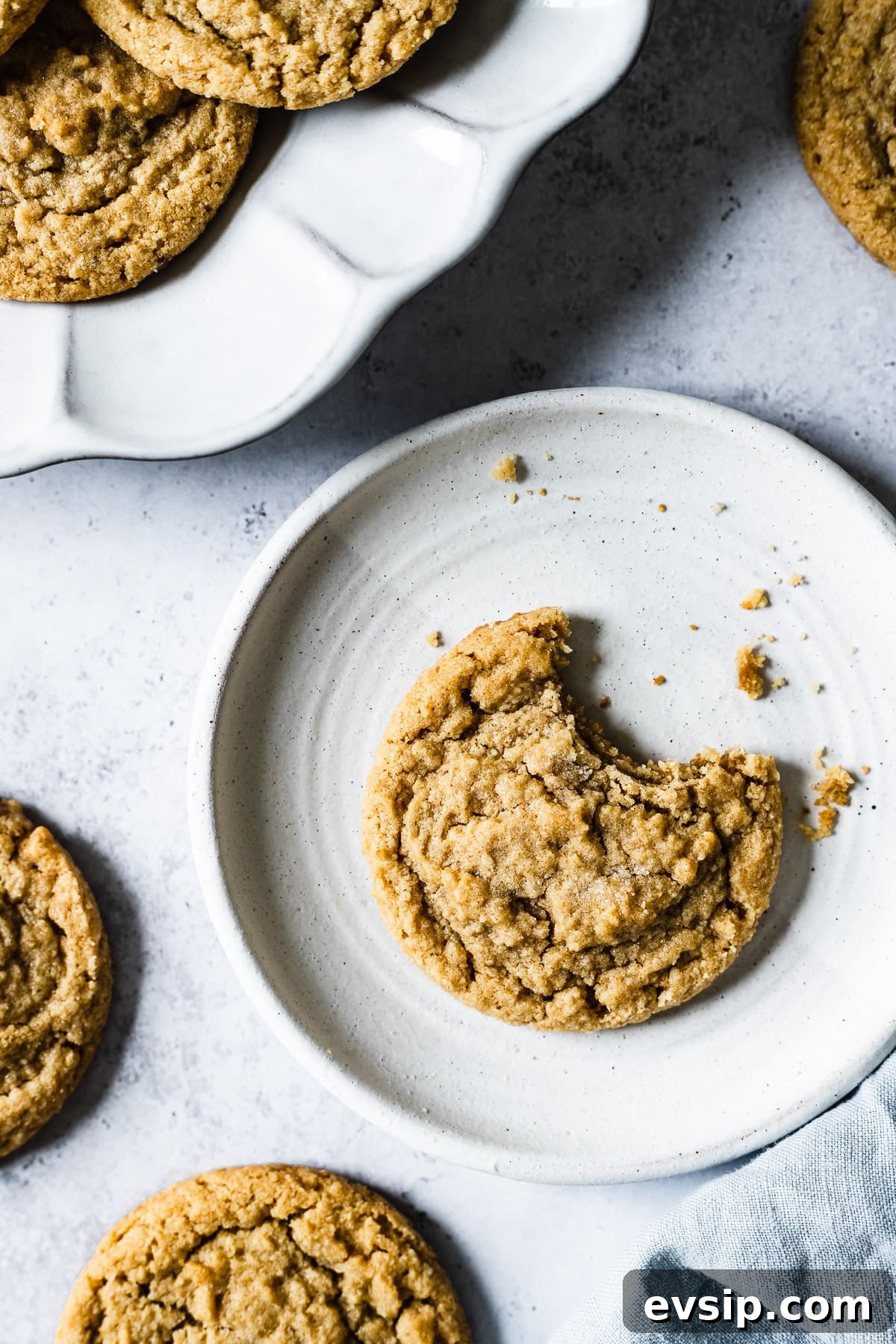 A cookie with a bite taken out of it on a round plate.