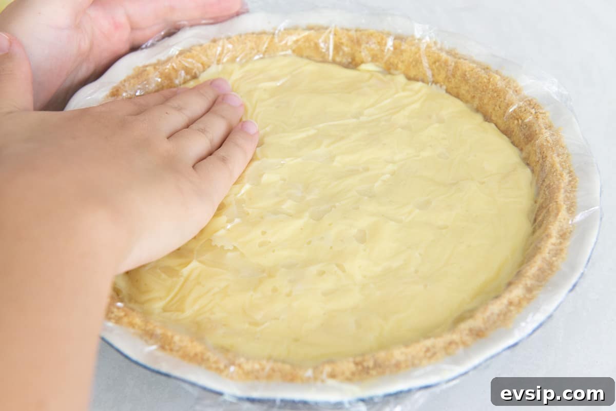 Classic Coconut Cream Pie Recipe: Silky, Homemade Dessert 13 Pressing a piece of plastic wrap over the pudding again