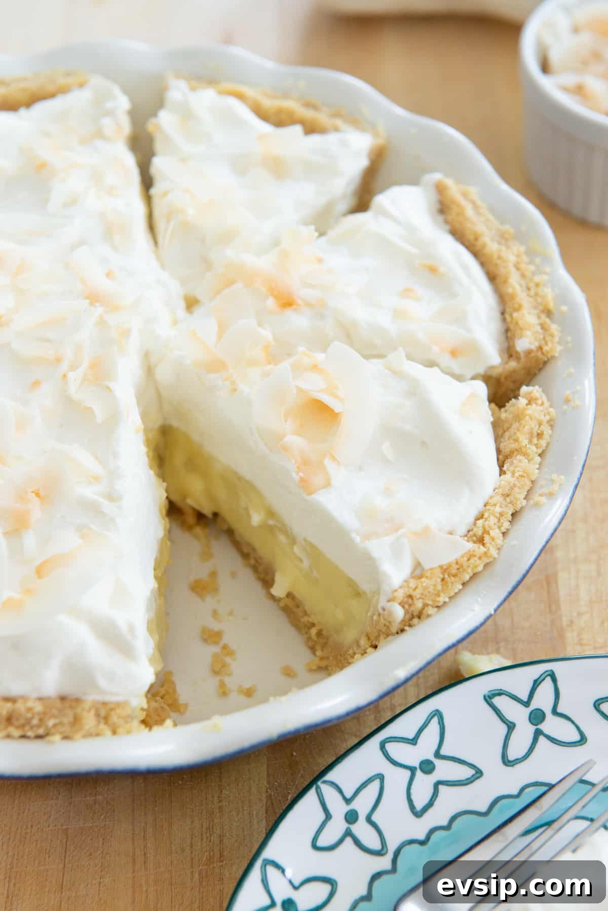 Classic Coconut Cream Pie Recipe: Silky, Homemade Dessert 16 Freshly made coconut cream pie in a pie plate with slices cut