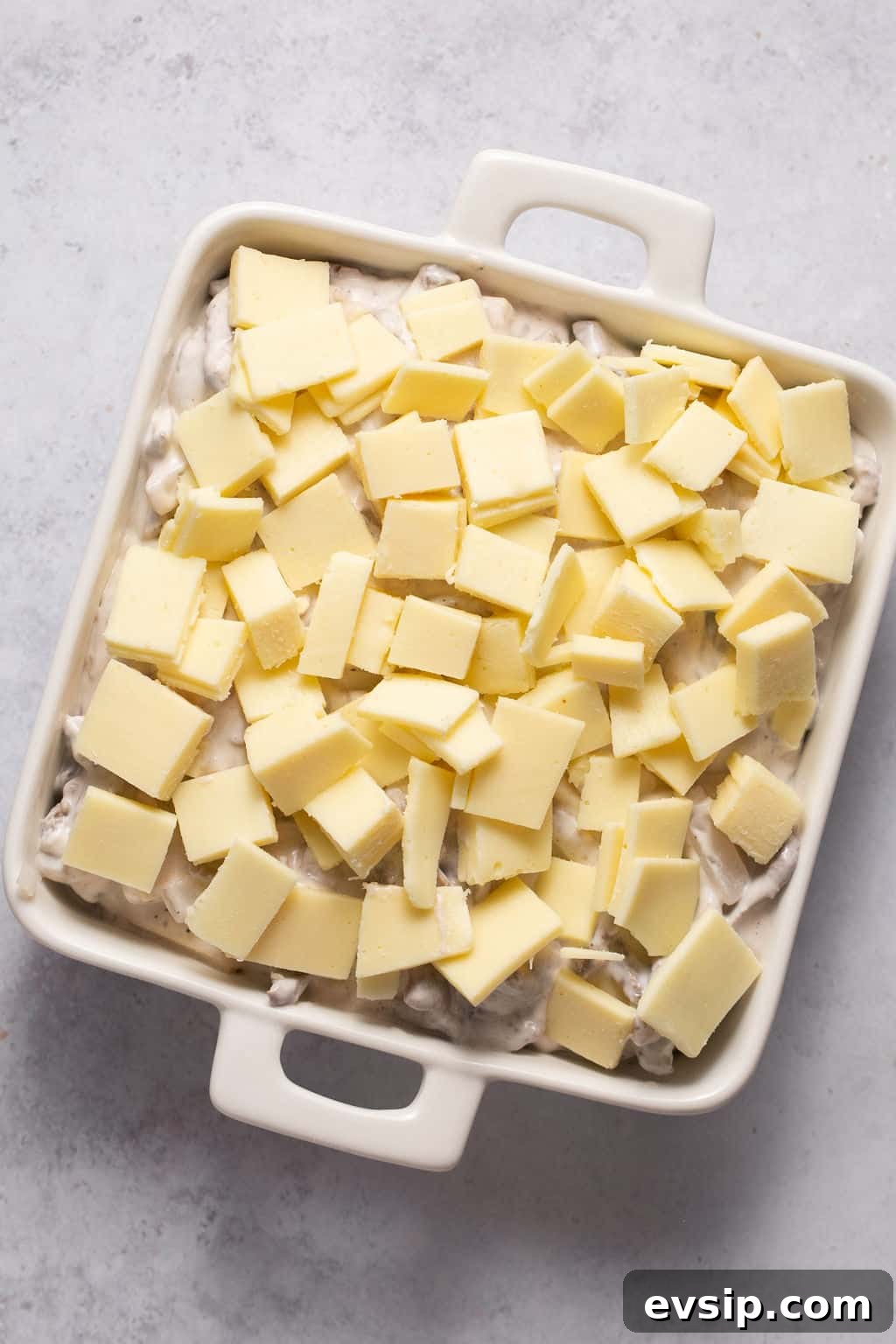 dip topped with cheese in square pan