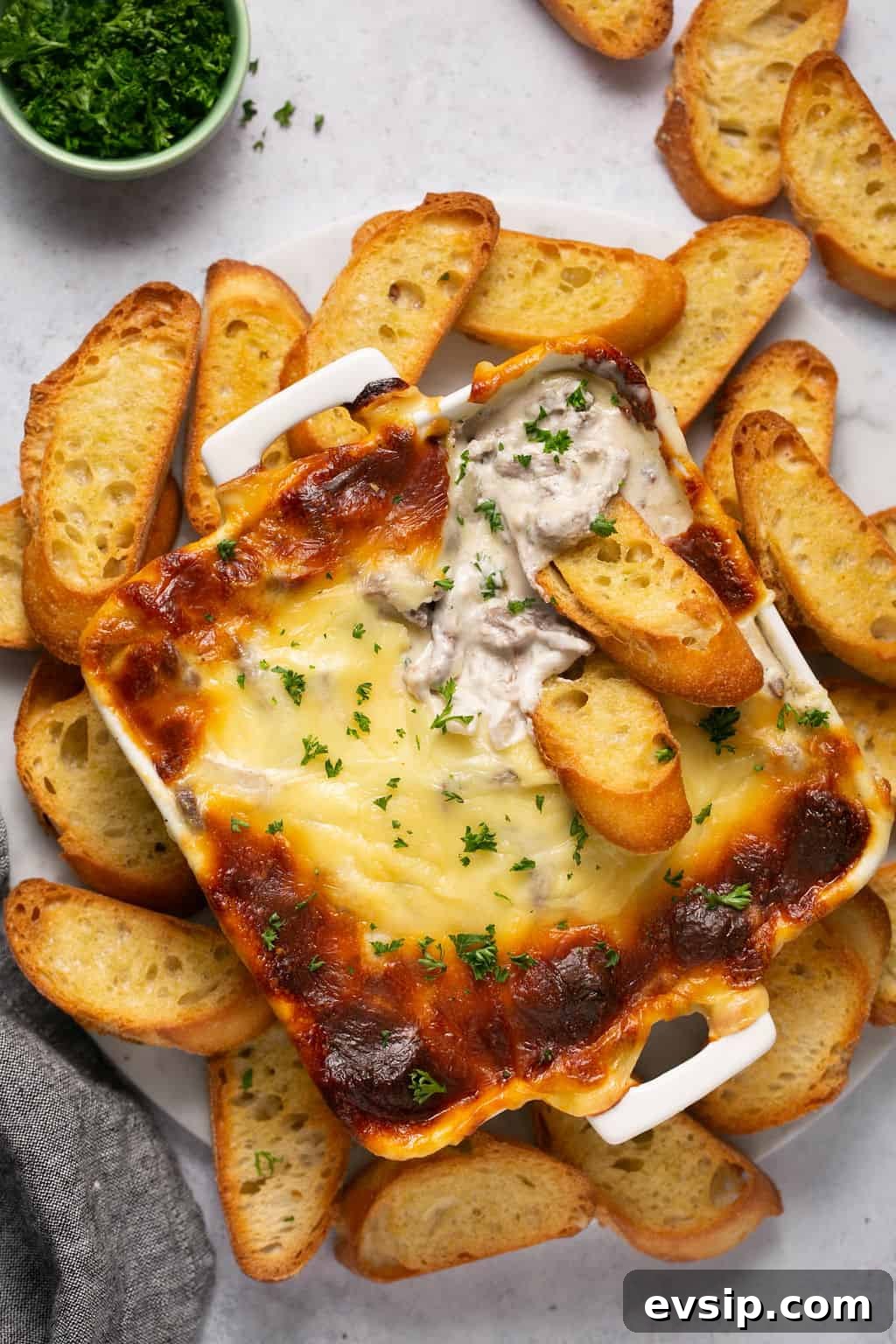 Philly cheesesteak dip in pan with slides of bread around