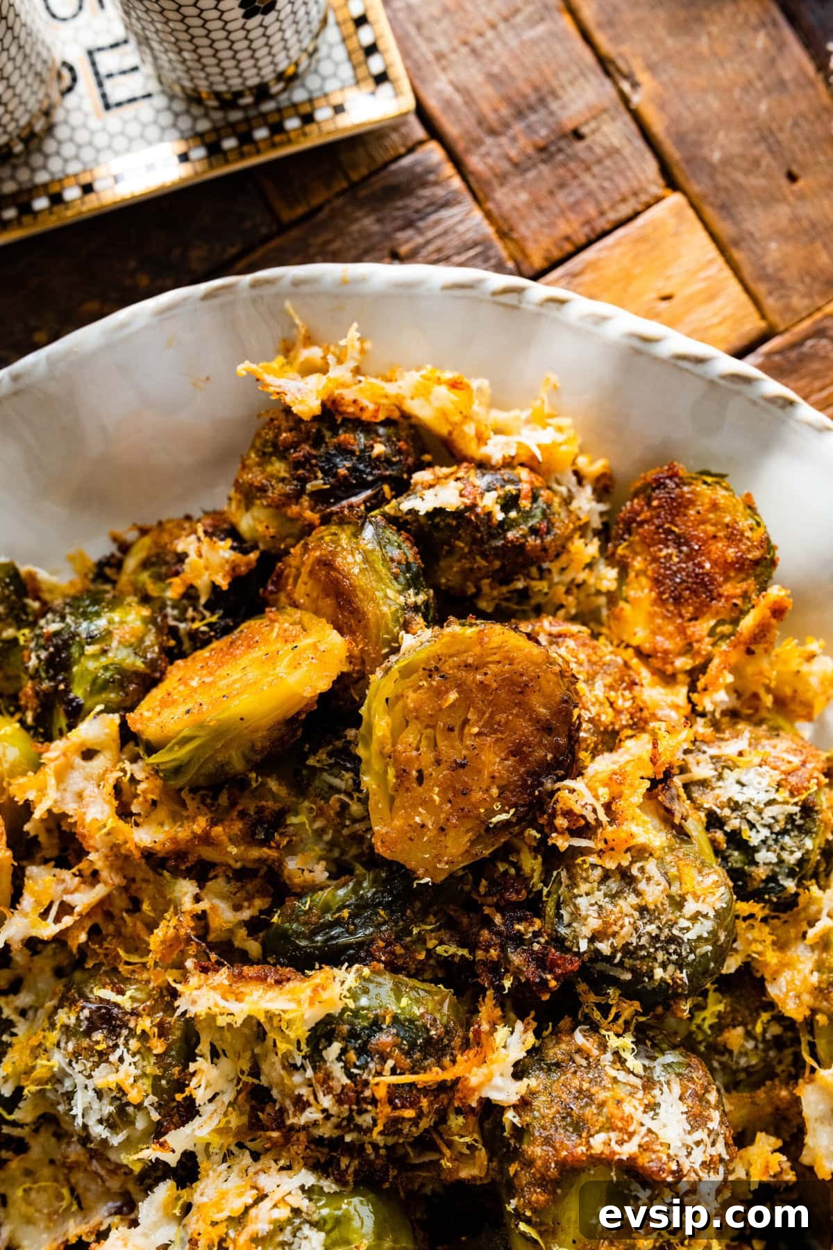 Parmesan Brussels Sprouts Recipe on a serving platter with serving utensils ready to serve. Close up of the final dish.
