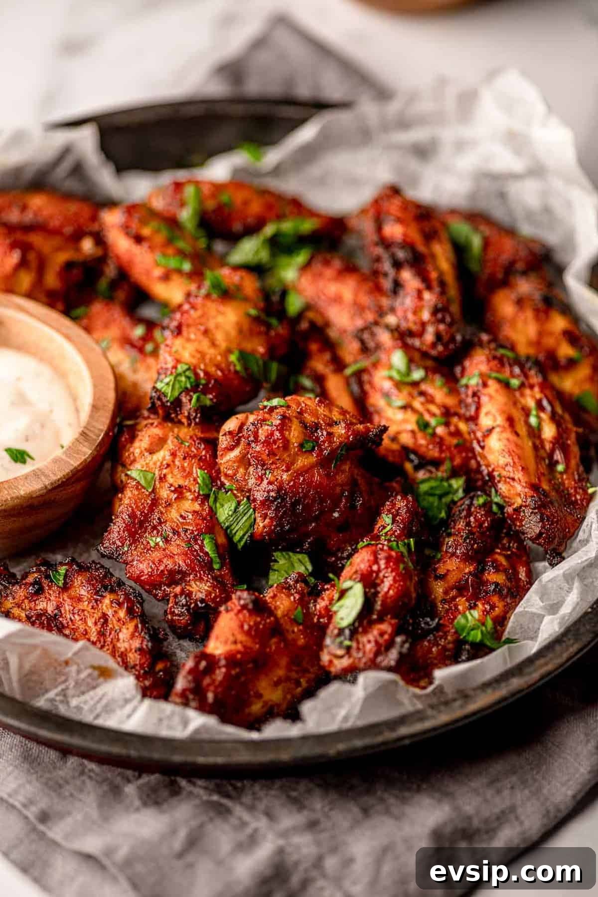Dry rub wings on a tray lined with wax paper.