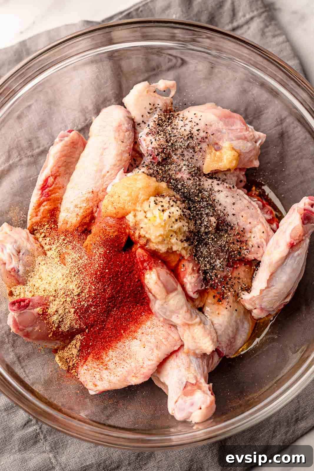Spices in a bowl on top of chicken wings.