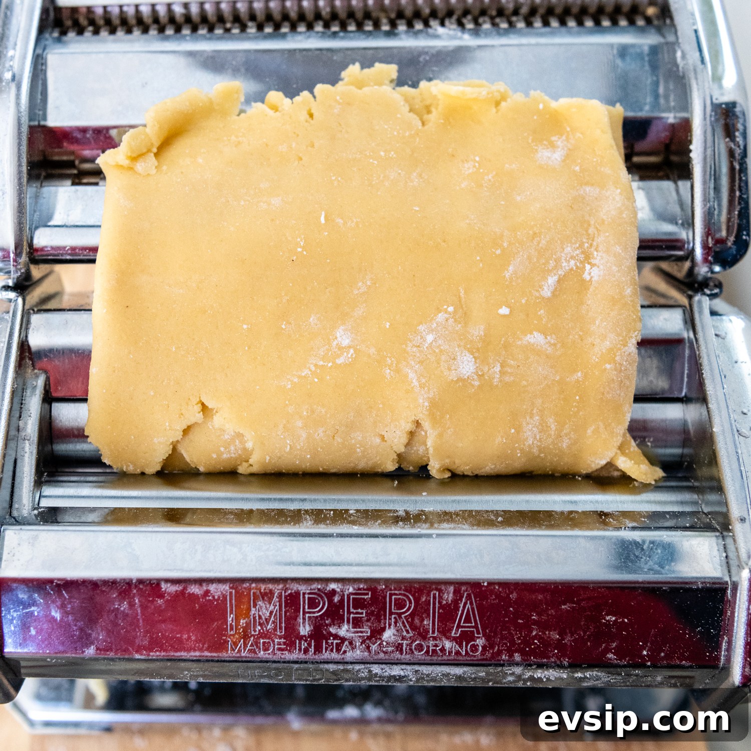 Folded dough being placed in pasta machine for second pass.