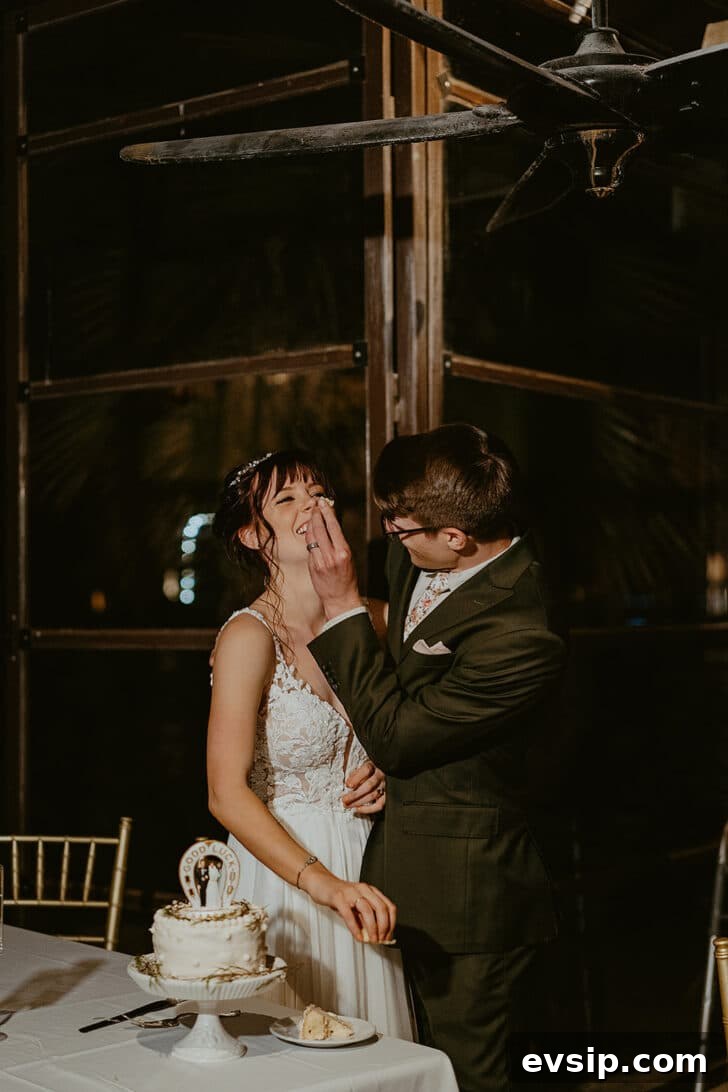 A groom smashing cake into a bride's face in a dark restaurant.