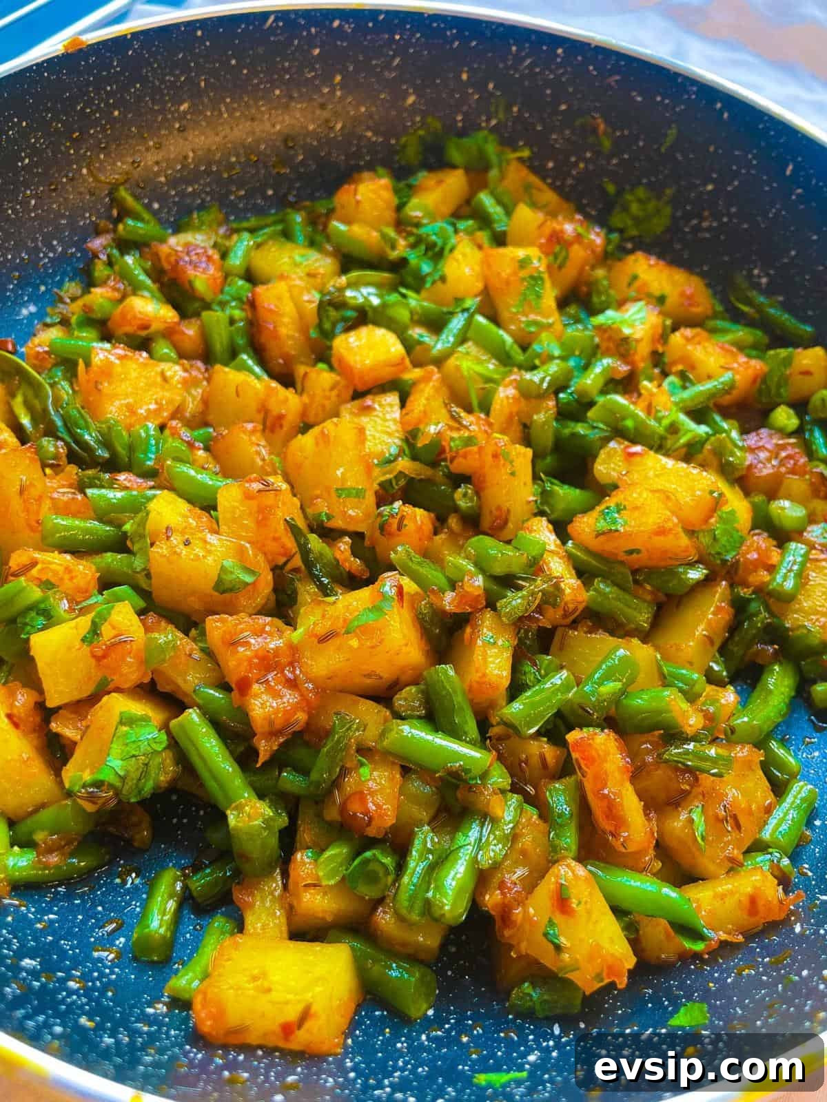 A close up of a pan of green bean and potato curry (Aloo Phali)