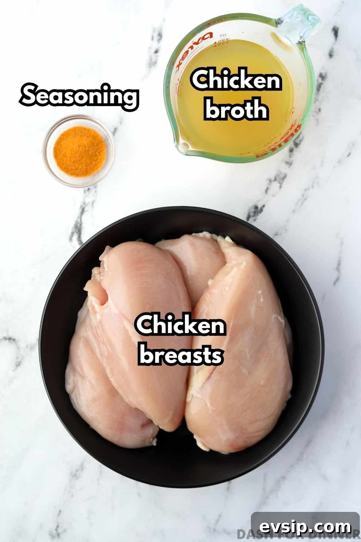 Juicy Shredded Chicken Made in a Dutch Oven 3 A plate with four chicken breasts, a small measuring cup of chicken broth, and some seasoned salt.