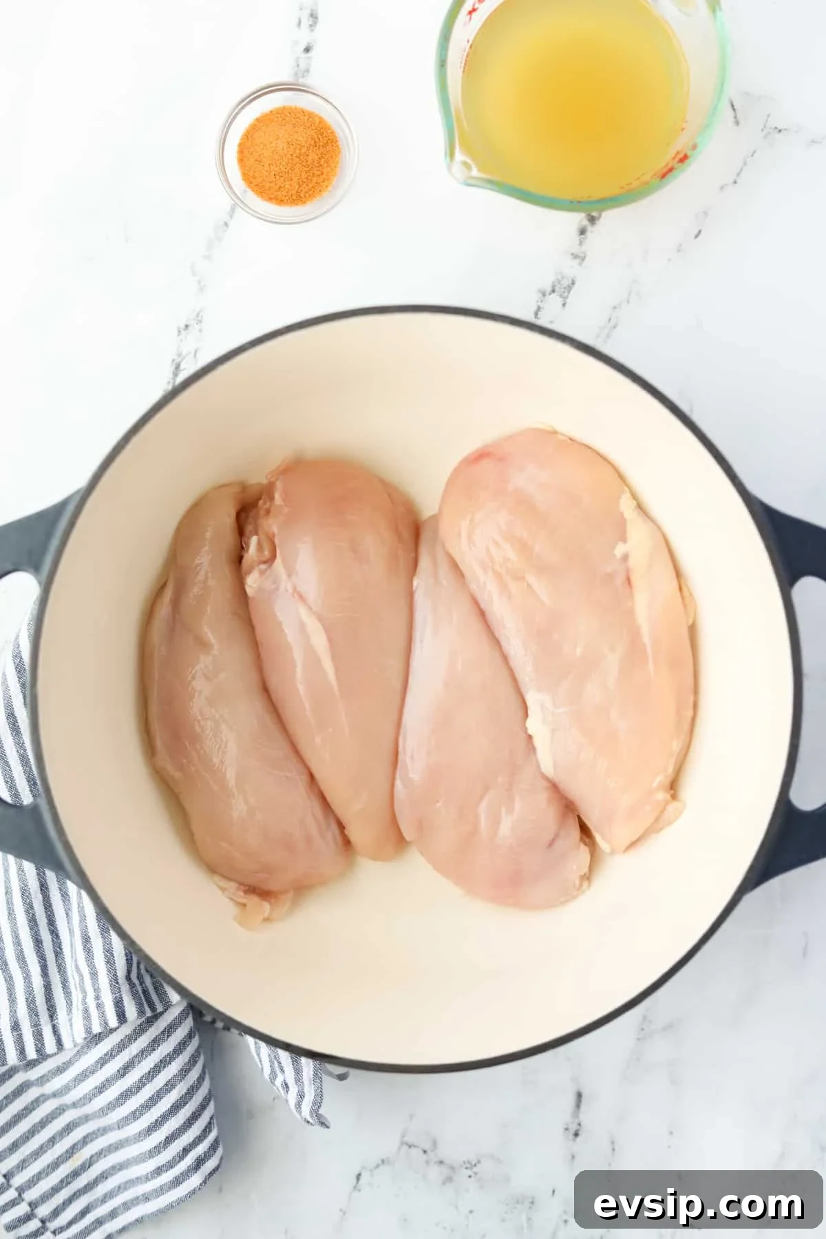 Juicy Shredded Chicken Made in a Dutch Oven 4 A Dutch Oven with four chicken breasts inside.
