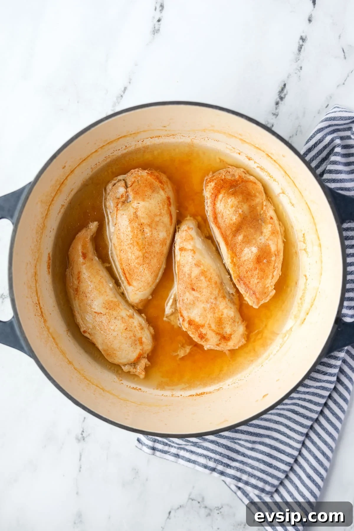 Juicy Shredded Chicken Made in a Dutch Oven 7 Cooked chicken breasts in a poaching liquid.