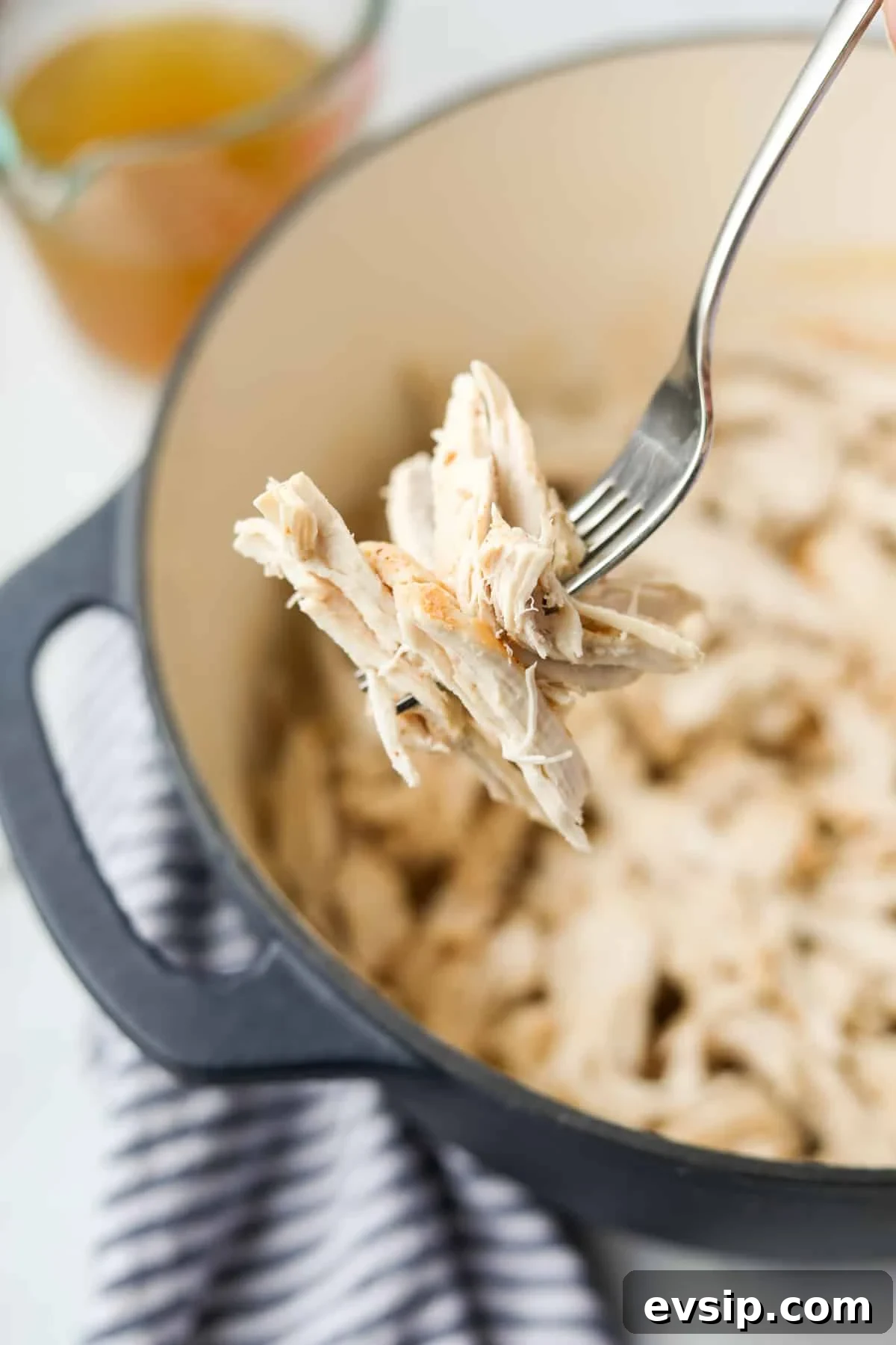 Juicy Shredded Chicken Made in a Dutch Oven 9 A fork with a portion of shredded chicken on it.