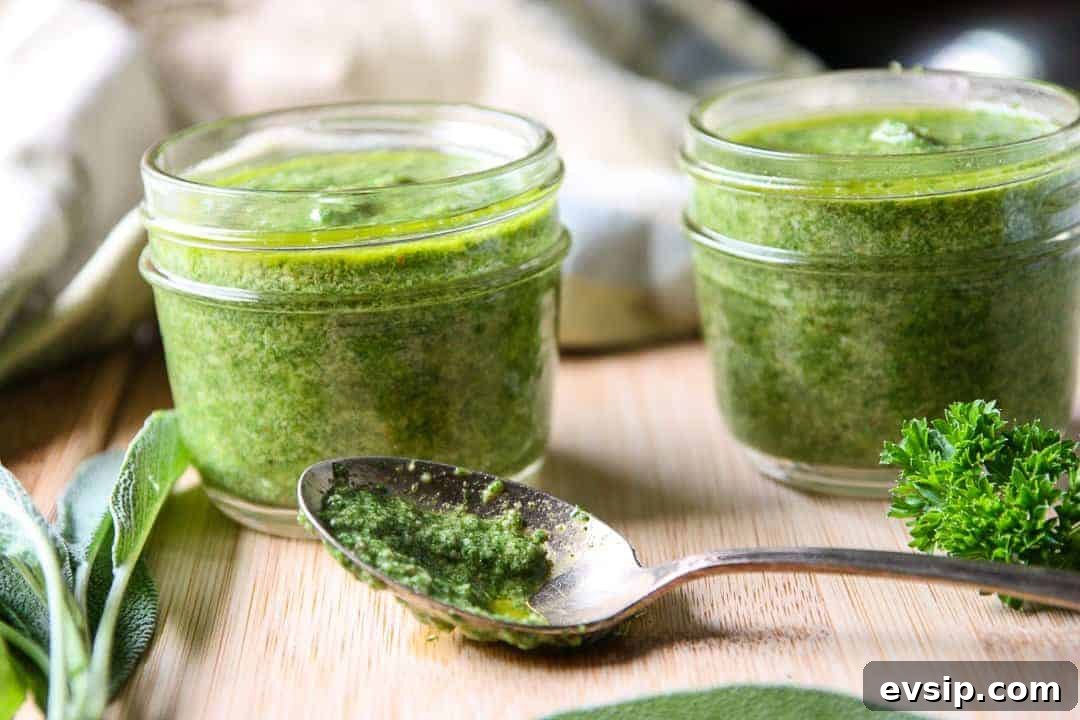 A jar of pesto on a cutting board with a spoon