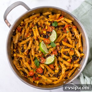 30-Minute One-Pot Chicken Enchilada Pasta Recipe 10 One pot chicken enchilada pasta in a skillet with black beans, corn, tomatoes and lime wedges
