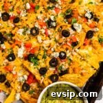 Buffalo Chicken Nachos Recipe for Crispy, Spicy Game Day Nachos 12 A top down view of buffalo chicken nachos on a tray served with guacamole.