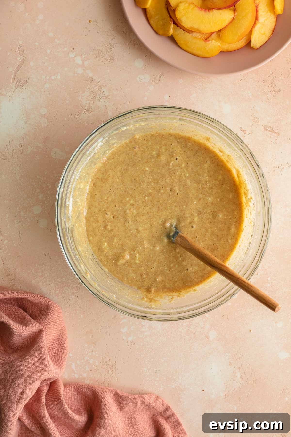 Peach Ricotta Cake Recipe — Moist Summer Fruit Dessert 6 Peach cake batter in a glass bowl with a spatula inserted into it.