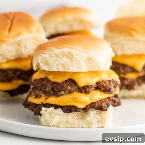 Top Blackstone Griddle Appetizers for Parties and Game Day 15 Three cheeseburger sliders on a white plate.
