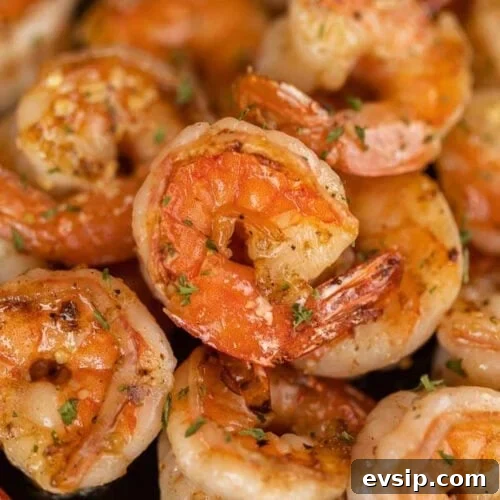 Top Blackstone Griddle Appetizers for Parties and Game Day 3 Close up of shrimp on a plate with herbs.