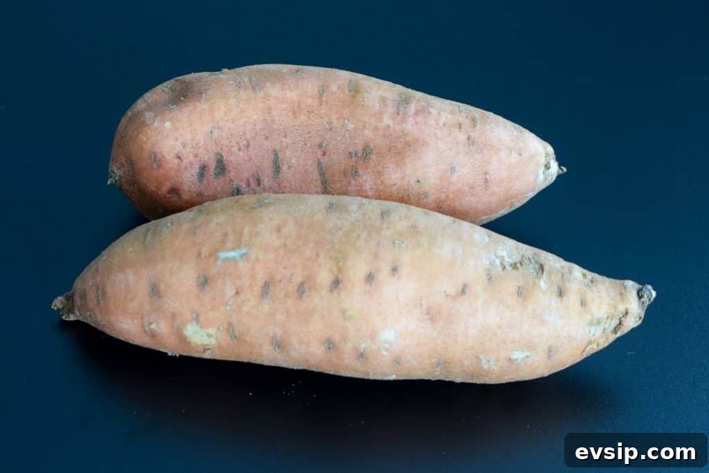 two sweet potatoes on black background
