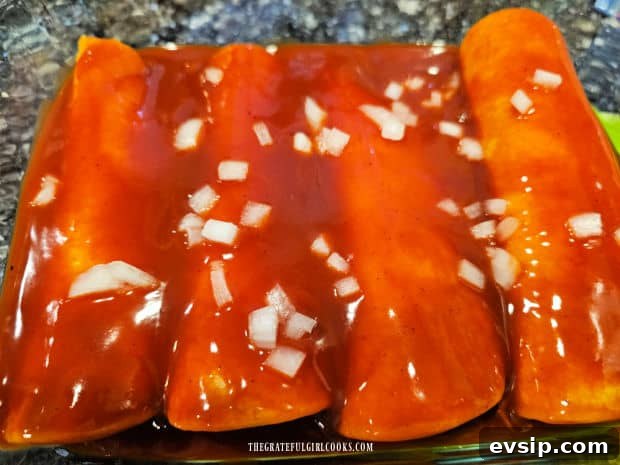 Air Fryer Cheese Enchiladas - The Grateful Girl Cooks! Enchilada sauce and chopped onions top the enchiladas in dish.