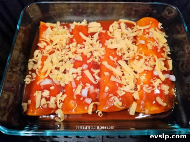 Air Fryer Cheese Enchiladas - The Grateful Girl Cooks! Grated cheddar cheese is divided on top of the cheese-filled enchiladas