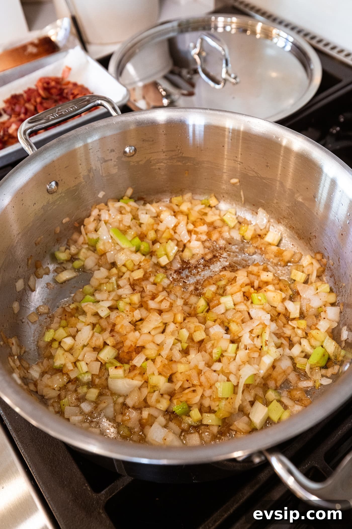 Large stockpot filled with browned cooked onion and celery after being on the heat.