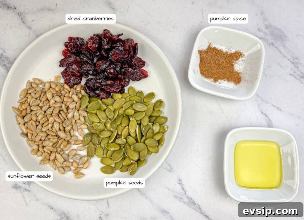 A plate contains dried cranberries, sunflower seeds, and pumpkin seeds. Nearby, small bowls hold pumpkin spice and olive oil. The items are labeled accordingly in the image.