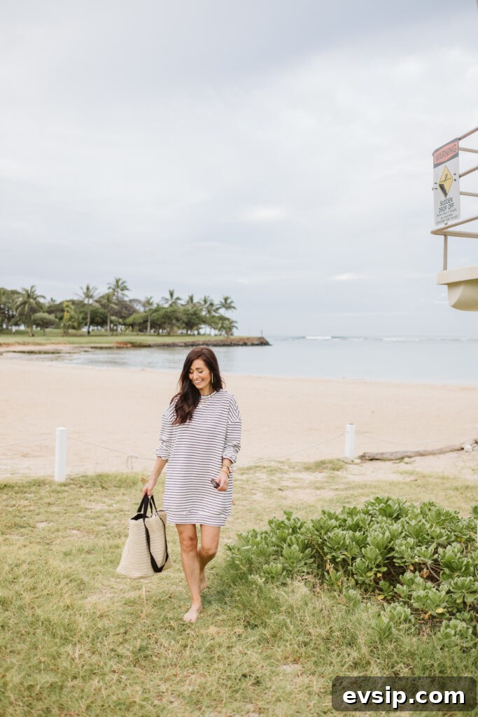 Tori walking in the black and white striped sweater dress on the beach from The Fraîche x PRIV Summer Collection