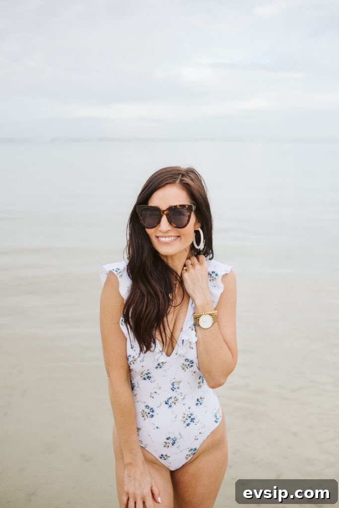 Tori smiling I the shallow water of Hawaii in ruffle one-piece bathing suit from The Fraîche x PRIV Summer Collection
