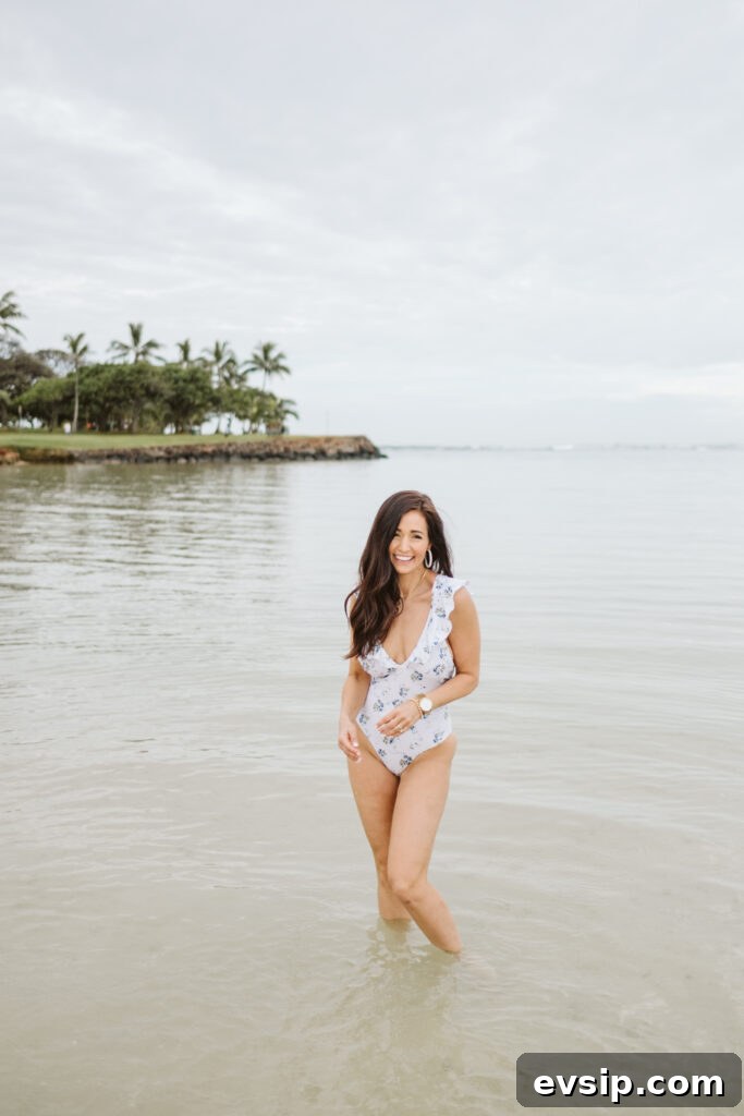 Tori smiling I the shallow water of Hawaii in ruffle one-piece bathing suit from The Fraîche x PRIV Summer Collection