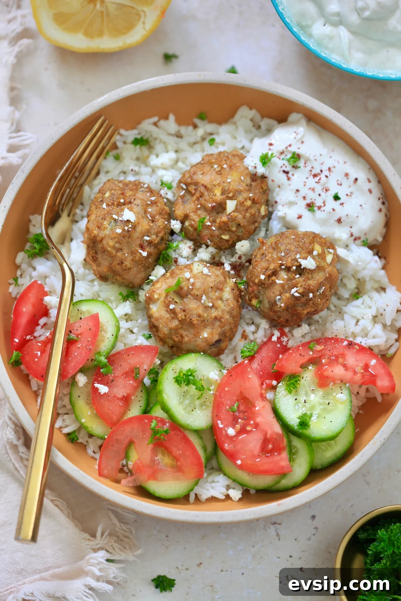 bowl with rice, meatballs, tomato and cucumber